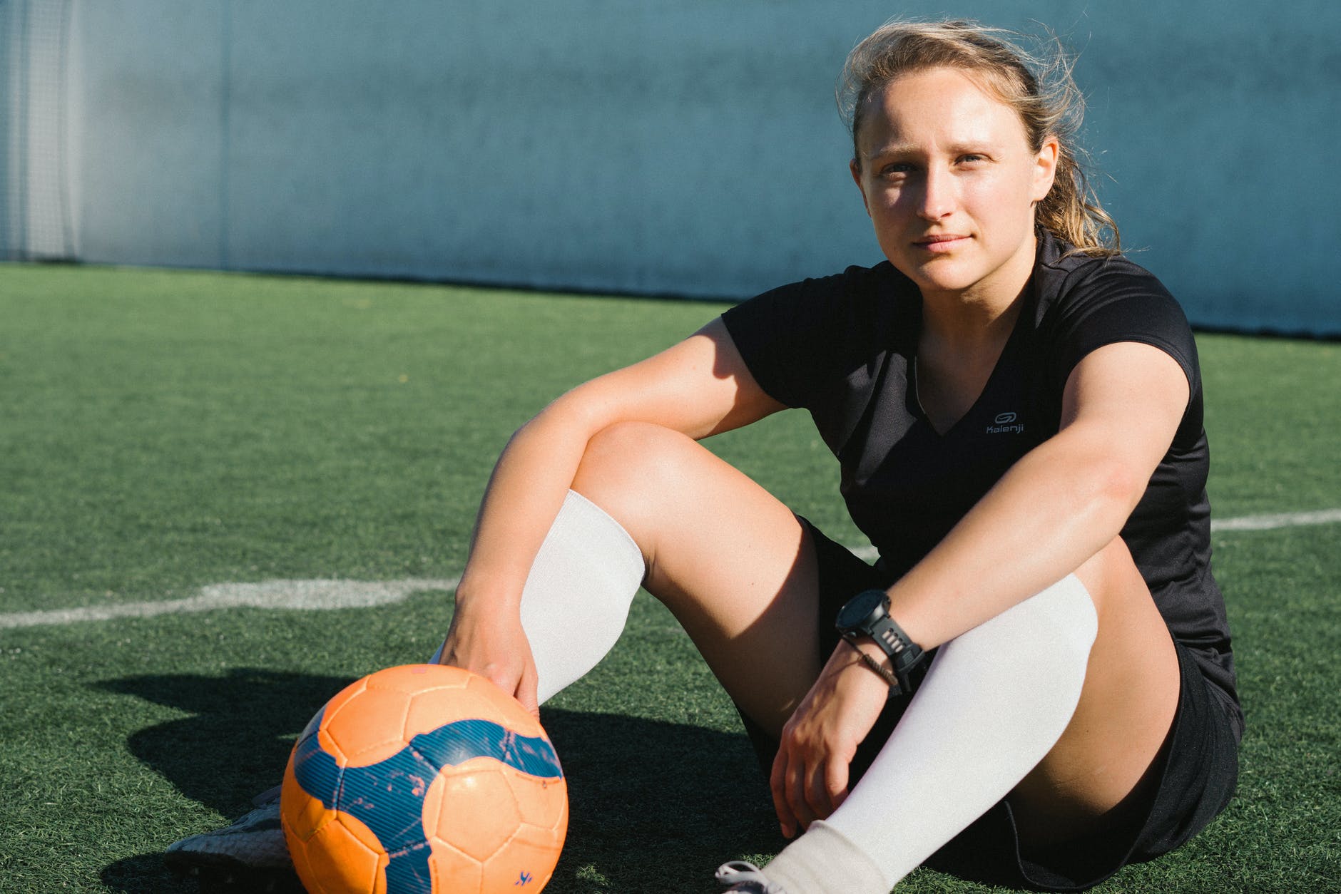 woman in black t shirt and black shorts sitting on grass